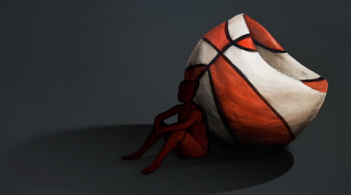 A silhouette of a female basketball player leaning up against a deflated orange and white basketball